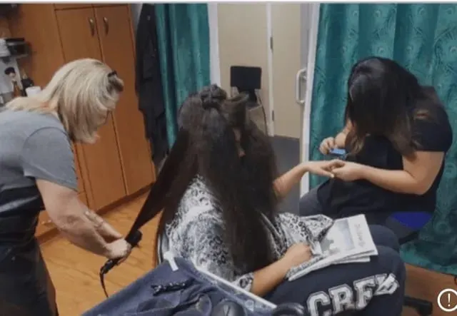 Janet working on a client's long dark hair in her studio